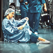 Healthcare worker sitting in hallway
