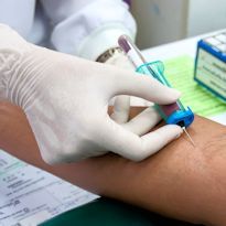 Healthcare worker withdrawing blood from arm
