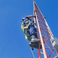 Worker wearing fall protection climbing tower
