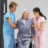 Two healthcare workers assisting a patient to walk
