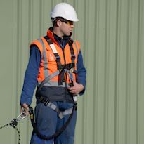 Worker wearing fall arrest system